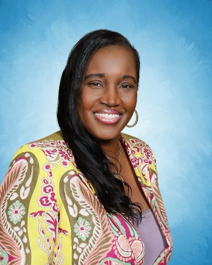 Ife Ewing, founder of A Caring Heart Early Learning Center, smiling warmly in a colorful paisley jacket.